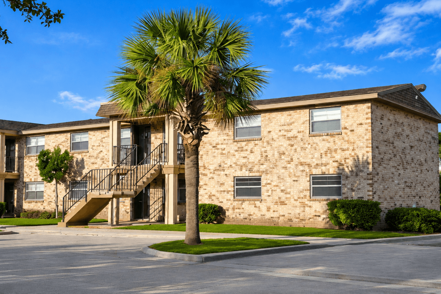 A stone building with a palm tree in front.